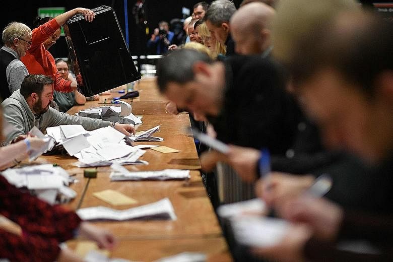 Vote counting under way for the Irish elections at the Dublin City count centre, in the RDS centre, in Ireland yesterday. An exit poll showed the nation's three biggest political parties in a dead heat.
