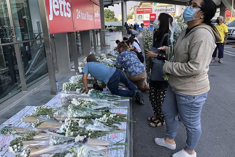 People laying bouquets of flowers yesterday outside the mall in Thailand where a shooting rampage took place on Saturday. ST PHOTO: HATHAI TECHAKITTERANUN