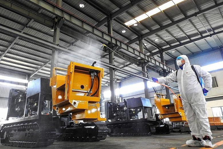 A staff member disinfecting machines before workers return to work from holidays at a factory in Lianyungang in China's Jiangsu province. Companies battered by the coronavirus outbreak in Hong Kong are being helped by lenders that are easing borrowin