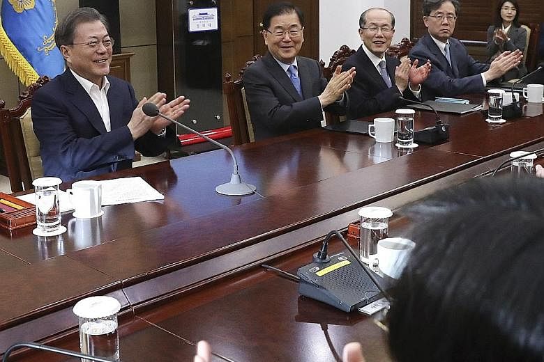 South Korean President Moon Jae-in (far left) and his top secretaries react after hearing that South Korean director Bong Joon-ho won four Academy Awards, prior to a meeting at the presidential office in Seoul. The news was also closely watched by So