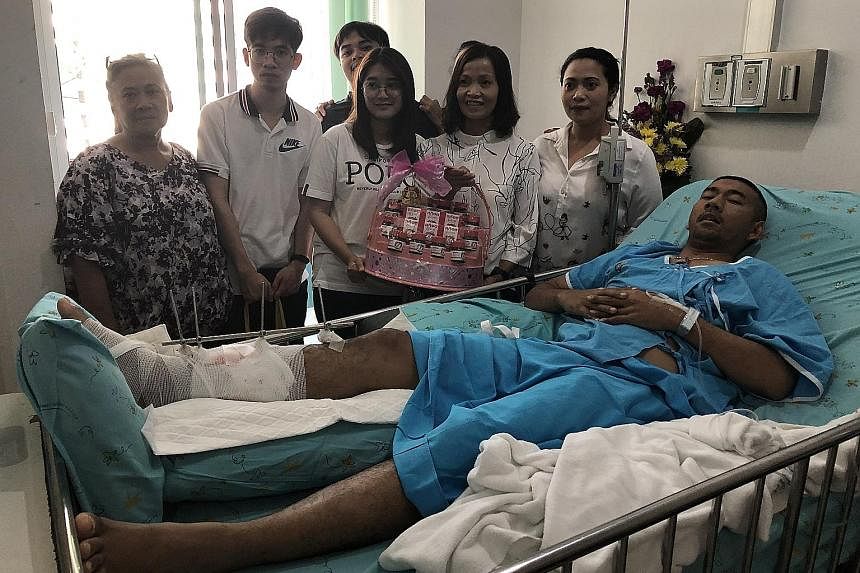 Police corporal Korakot Ampanngeun, who was shot in the leg by the gunman, is visited by his family at Maharat Hospital. Many people have flocked to major hospitals to donate blood. A woman laying a bouquet of flowers outside Terminal 21 mall in Nakh