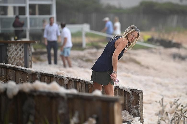 Residents of Sydney's Collaroy suburb inspecting their homes for damage after storms uprooted trees and resulted in houses being coated in ocean foam.