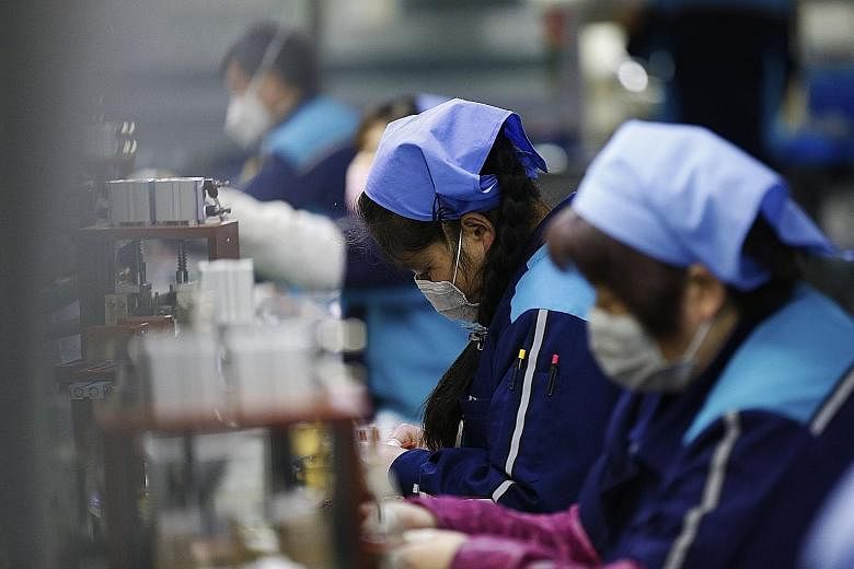 Workers at an electronic components factory in Sihong county, Jiangsu province, on Monday. The coronavirus outbreak in China could lead to extended factory closures that will slow manufacturing and weigh on global supply chains.