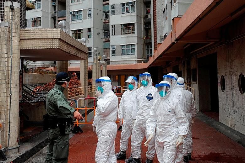 Police in protective gear waiting to evacuate residents from a public housing building in Hong Kong's Tsing Yi district yesterday. The building has two confirmed coronavirus cases.