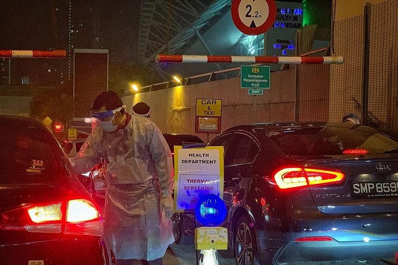 Thermal scanning being conducted on travellers at the Johor Baru Customs, Immigration and Quarantine complex on Monday. ST PHOTO: ARIFFIN JAMAR