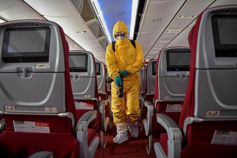 A man in a protective suit disinfecting the cabin of a Hainan Airlines flight at the Haikou Meilan International Airport in China's Hainan province last Friday. PHOTO: REUTERS