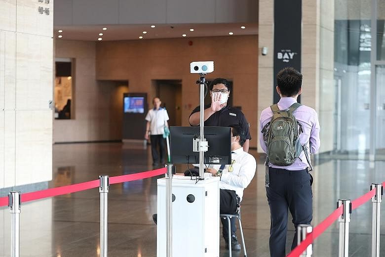 A thermal scanner at the entrance of Marina Bay Financial Centre Tower 3. The 300 employees working on the 43rd floor, the same floor as a man confirmed to be infected with the virus, left by 12pm yesterday. ST PHOTO: TIMOTHY DAVID
