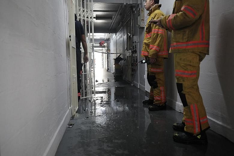 SCDF officers at the Ang Mo Kio flat yesterday. The man was found in the living room with burn injuries and taken to Tan Tock Seng Hospital, where he later died. PHOTO: LIANHE ZAOBAO