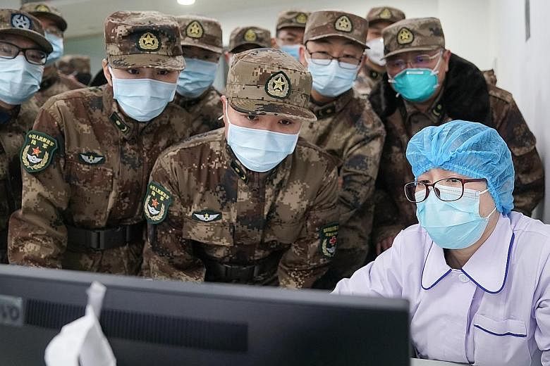 A doctor being disinfected by his colleague earlier this month in a quarantine zone in Wuhan, the city in China's central Hubei province that is the epicentre of the coronavirus outbreak. A People's Liberation Army medical team starting work on Jan 2