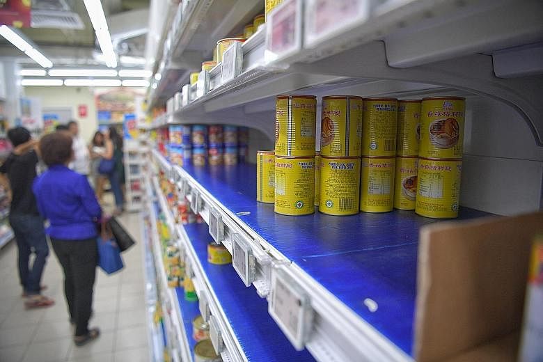Shoppers bought up canned food (above) and stocked up on masks in the light of the coronavirus outbreak.