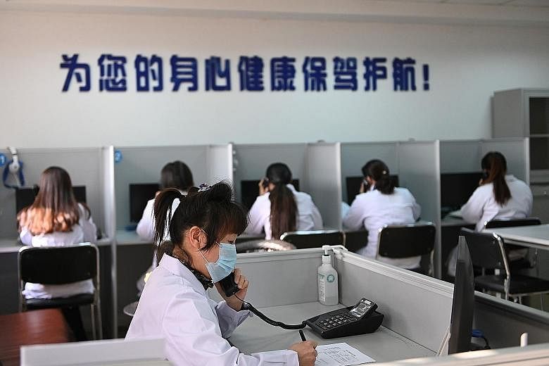 A hotline operator for a free counselling service in Shenyang, China, answers a phone call while wearing a face mask as the country is hit by an outbreak of the coronavirus.