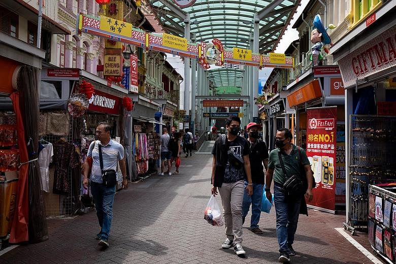 Shoppers wearing protective masks in a shopping street in Singapore's Chinatown area last week. A decline in overall retail sales last year suggests the spread of the coronavirus can dampen consumer sentiment, said Colliers International, but rents a