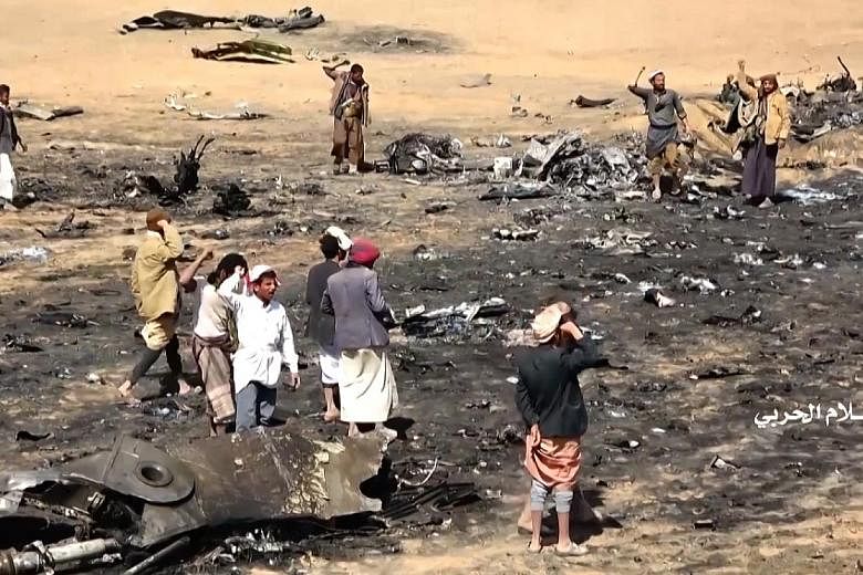 A screen grab from a video released by the Houthi Military Media Office on Saturday showing Yemenis gathering at the site of the downed Saudi Tornado aircraft in Yemen's northern Al-Jawf province.
