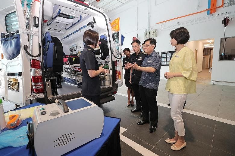 Deputy Prime Minister Heng Swee Keat and Senior Parliamentary Secretary for Home Affairs and National Development Sun Xueling being briefed on decontamination procedures by Singapore Civil Defence Force (SCDF) Lieutenant-Colonel Janice Oh (left) at K