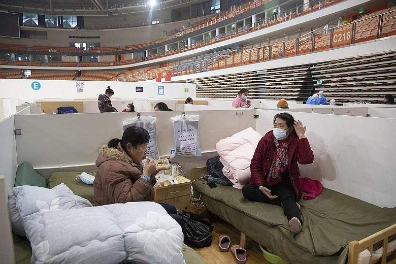 Patients at Wuhan Fangcang hospital, a makeshift hospital to treat coronavirus patients, in Wuhan city in China's Hubei province last Friday. The National Health Commission yesterday reported 2,009 new cases, down from 2,641 the previous day. PHOTO: 