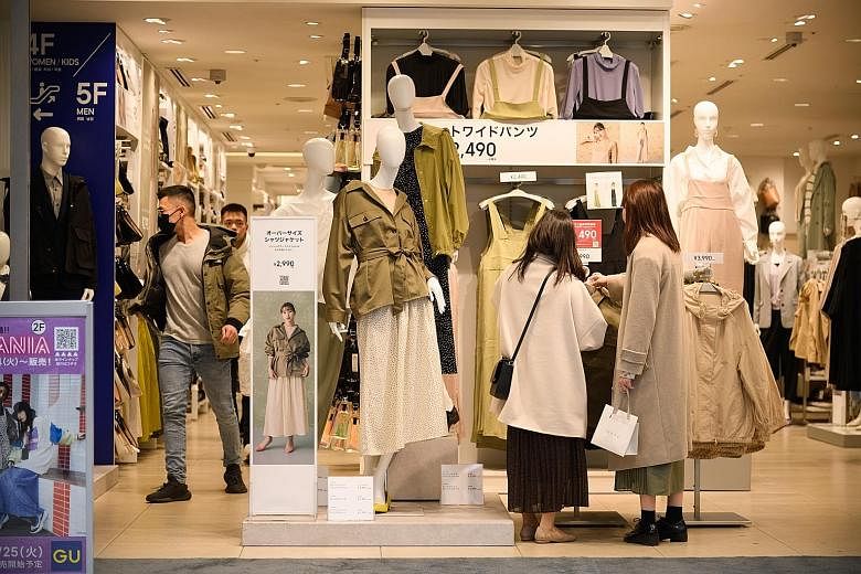 Customers at a GU clothing store in the Ginza area in Tokyo, Japan, last Saturday. According to a preliminary estimate by the Cabinet Office yesterday, Japan's gross domestic product shrank at an annualised pace of 6.3 per cent from the previous quar