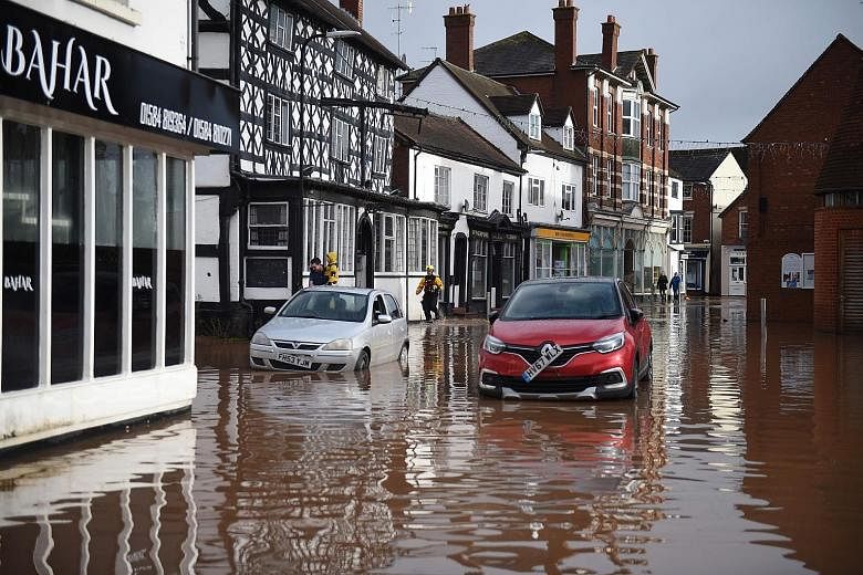 A flooded high street in Tenbury Wells in Worcestershire, western England, yesterday. More than a month's worth of rain fell in 48 hours in some parts of Britain. PHOTO: AGENCE FRANCE-PRESSE