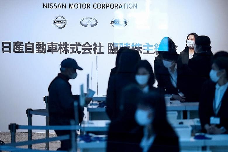 People arriving at Nissan Motor's extraordinary shareholders meeting in Yokohama, Japan, yesterday, where new chief executive officer Makoto Uchida received a barrage of furious questions.