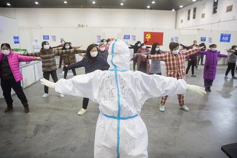 Patients exercising with medical staff inside the Wuhan Fang Cang makeshift hospital in Wuhan on Monday.