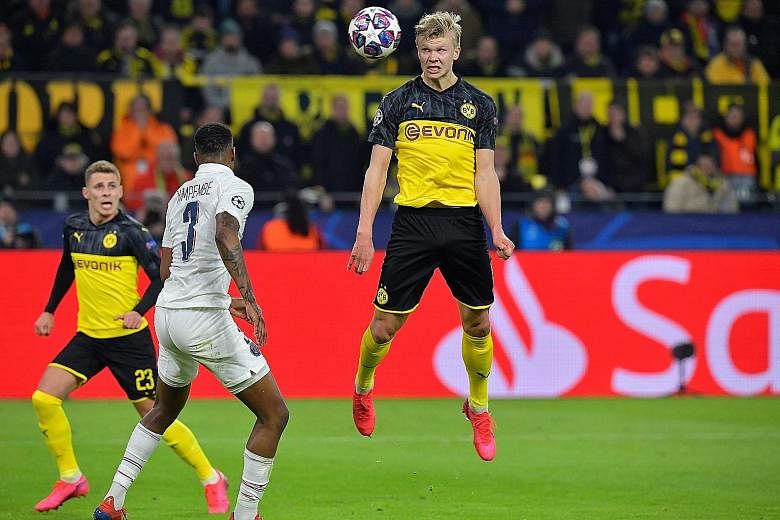 Borussia Dortmund's forward Erling Braut Haaland (centre) heading the ball next to Paris Saint-Germain's French defender Presnel Kimpembe during the first leg of their Champions League last-16 tie in Germany on Tuesday. PHOTO: AGENCE FRANCE-PRESSE