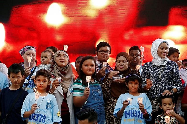 Family members holding candles during the fifth annual remembrance event for the missing Malaysia Airlines Flight MH370 in Kuala Lumpur in March last year. PHOTO: REUTERS