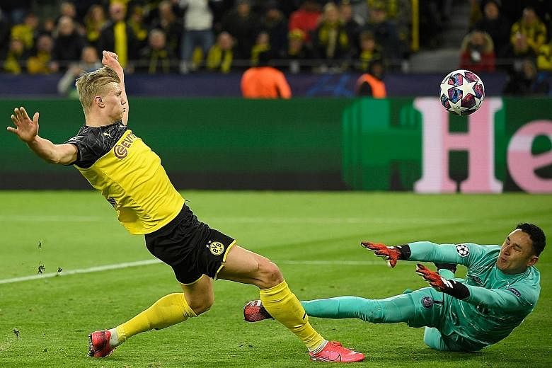 Erling Braut Haaland lifting the ball over PSG goalkeeper Keylor Navas to score the first goal. Dortmund have the edge in the tie after the Norwegian teenager's two goals. PHOTO: AGENCE FRANCE-PRESSE