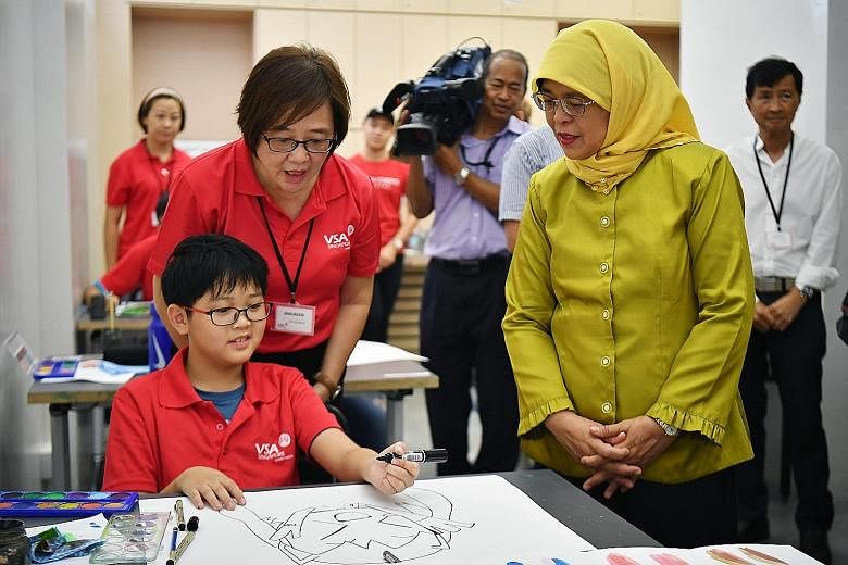 President Halimah Yacob and VSA Singapore executive director Maureen Goh observing student Royce Tai, 13, working on his drawing in VSA Artspace @ Bedok yesterday. Her visit was part of the President's Challenge outreach efforts to help vulnerable gr