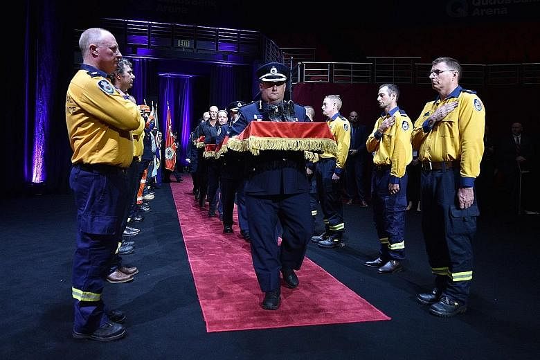 The boots of firefighters who died in the Australian bush fires being carried into a state memorial in Sydney yesterday.
