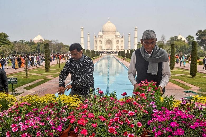 Workers planting flowers in front of the Taj Mahal in Agra on Saturday, ahead of US President Donald Trump's visit to India. His 36-hour trip will include a visit to the world-famous monument, where he will watch the sunset with First Lady Melania Tr
