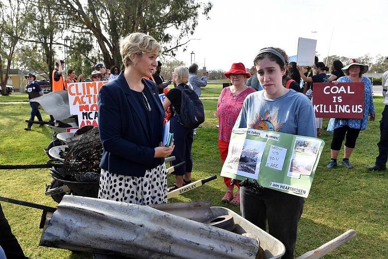 Independent MP Zali Steggall (far left) with a bush fire survivor at a demonstration in Canberra earlier this month. Ms Steggall's proposed Bill aims to end the deadlock on the climate debate in Australia. PHOTO: EPA-EFE