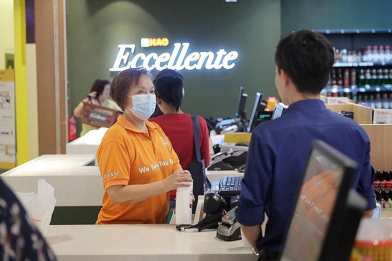 Cashier Joanne Sim at the Eccellente outlet in Kinex Shopping Mall. The 58-year-old, who takes vitamin C tablets daily to boost her immunity and dons a mask during work, said she is not worried about falling sick. ST PHOTO: GAVIN FOO