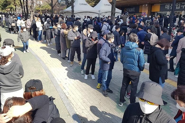People waiting to buy masks at a market in Daegu, South Korea, yesterday. South Korea has raised its virus alert to the highest red as the number of cases continues to spike, hitting 833 yesterday, with more than half linked to a cluster of infection