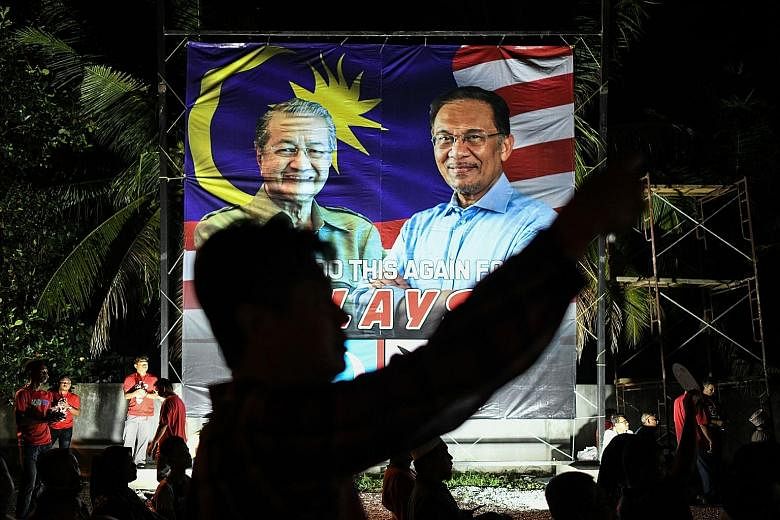 A banner during Malaysia's 2018 General Election showing Tun Dr Mahathir Mohamad (far left) and Datuk Seri Anwar Ibrahim running as part of Pakatan Harapan. Tensions have since plagued the coalition, causing it to break up.