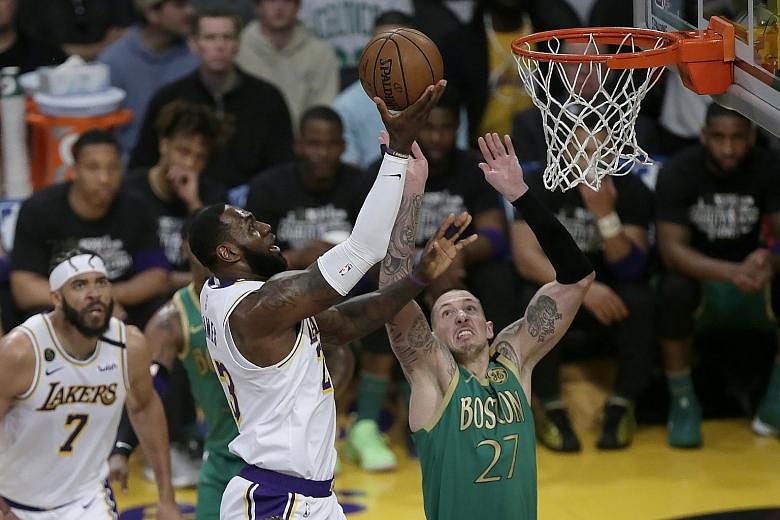 Los Angeles Lakers guard LeBron James going for a lay-up against Boston Celtics centre Daniel Theis at Staples Centre on Sunday. The forward finished with 29 points, including the winning shot with 30 seconds left. PHOTO: EPA-EFE