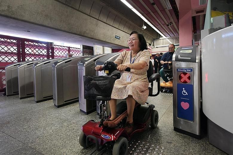 Madam Chew Bee Que and Mr Rohaizad Roslan (behind) at the Land Transport Authority's hands-free ticketing technology trial at Redhill MRT station in 2018. The latest trial is projected to take nine months.