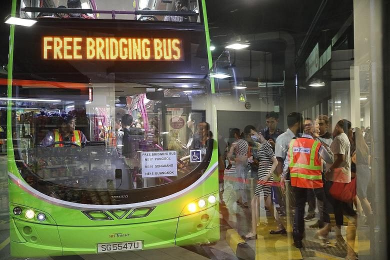 Commuters queueing (top and above) for the bridging bus service at Sengkang Bus Interchange. They took the free service to Buangkok MRT station to continue their journey on the North East Line. ST PHOTOS: ONG WEE JIN
