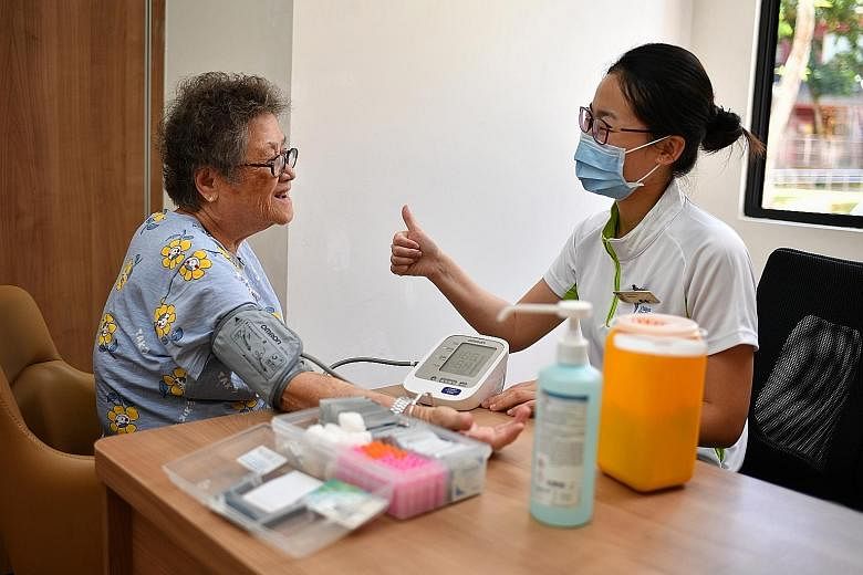 Above: Community nurse Lyu Wenchao giving Madam Ong Poh Suan the thumbs up after measuring her blood pressure on Thursday. In view of the coronavirus situation, Yishun Health increased the number of Community Nurse Post sessions to help residents con