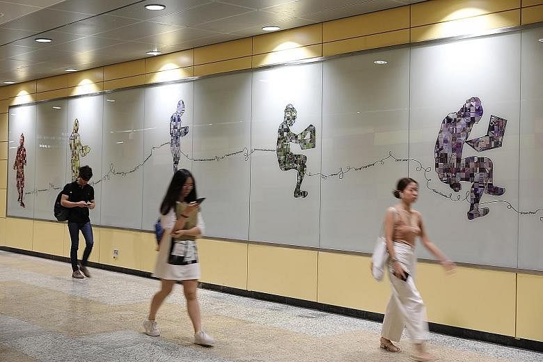 In Bencoolen station, two massive murals double as wayfinding guides – figures holding laptops (above) point the way to the Singapore Management University, while those holding pencils – signifying art – direct travellers to the Nanyang Academy of Fine Ar