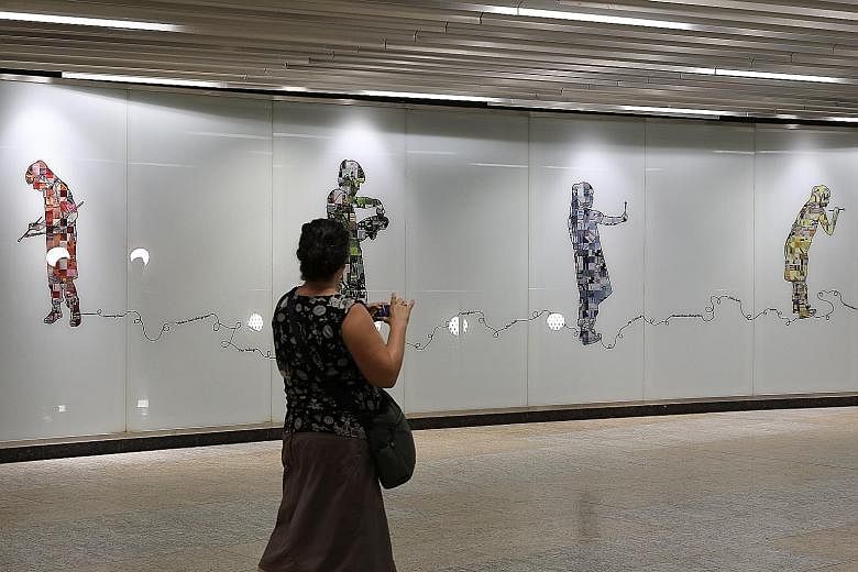 In Bencoolen station, two massive murals double as wayfinding guides – figures holding laptops point the way to the Singapore Management University, while those holding pencils (above) – signifying art – direct travellers to the Nanyang Academy of Fine Ar