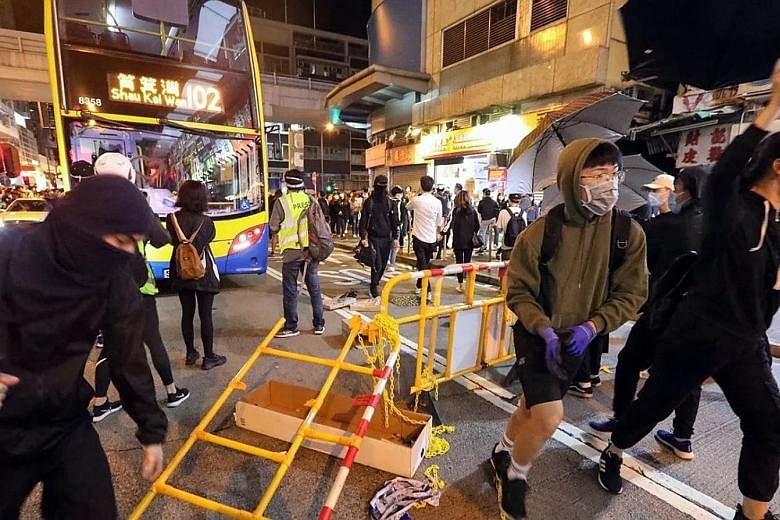Anti-government protesters setting up roadblocks in Nathan Road in Hong Kong's Kowloon district yesterday.