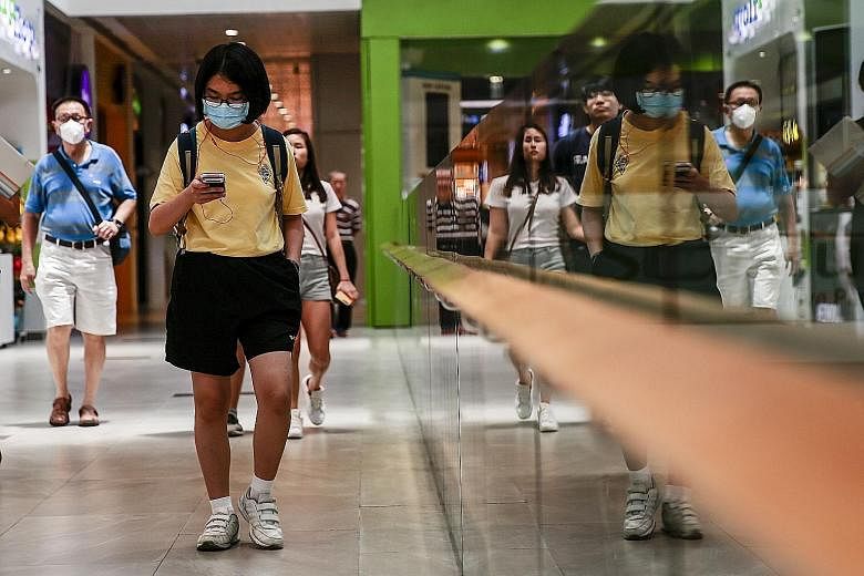 People seen with masks in a shopping mall in Singapore last Friday. The coronavirus outbreak is likely to hit consumer spending hard as it deters shoppers from frequenting malls and restaurants. Real estate consultancy CBRE Research expects prime flo