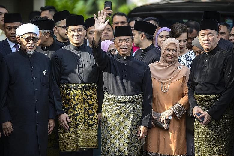 Above: Malaysia's new Prime Minister Muhyiddin Yassin waving outside his residence in Kuala Lumpur, with Datuk Seri Azmin Ali (second from left) by his side, before his inauguration yesterday. Left: Tun Dr Mahathir Mohamad speaking at a press confere