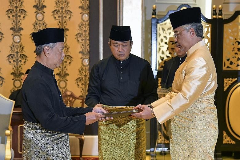 Malaysia's incoming Prime Minister Muhyiddin Yassin (far left) receiving documents from the King, Sultan Abdullah Ri'ayatuddin, before taking the oath as the country's new leader at the National Palace in Kuala Lumpur yesterday.