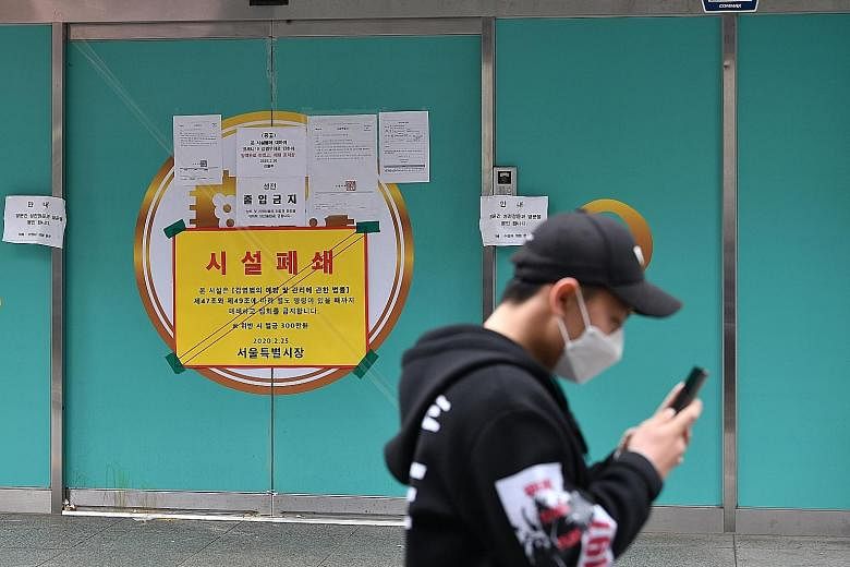A man walking past a branch of the Shincheonji Church of Jesus, the Temple of the Tabernacle of the Testimony, in Seoul. The church has been temporarily closed by the South Korean government to help prevent the spread of the coronavirus after a large