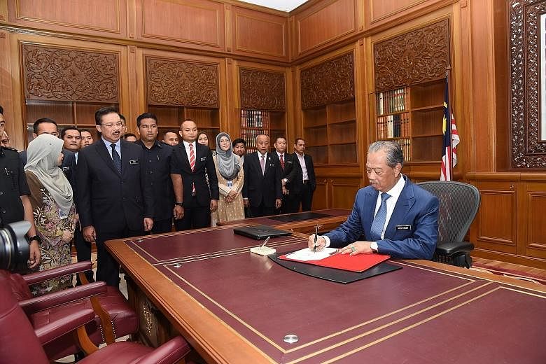 Malaysia's new Prime Minister Muhyiddin Yassin signing a document yesterday in his office in Putrajaya. He said in a speech broadcast over national television last night that he is a prime minister for all Malaysians, whatever their race or ethnicity
