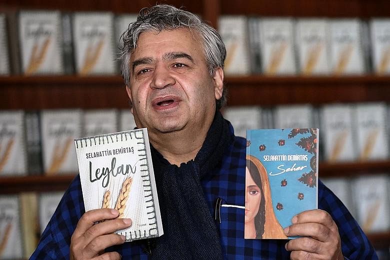 Dipnot has received threats from nationalists for publishing works by imprisoned Kurdish politician Selahattin Demirtas. Mr Emir Ali Turkmen (left), head of Dipnot, with Demirtas' books Leylan and Seher.