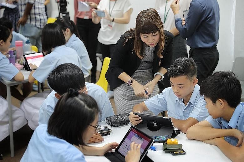 Ms Rozaina Rusli, head of student welfare at New Town Secondary School, looking on as Secondary 2 student Muhammad Izz Danial, 13, and his classmates took part in a cyber-wellness class last month. The trial programme at several secondary schools mak