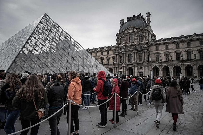 Visitors queueing outside the entrance to the Louvre in Paris yesterday after it reopened. It was forced to close for three days as the staff expressed concern about catching the coronavirus from visitors, but the museum presented a plan to the staff