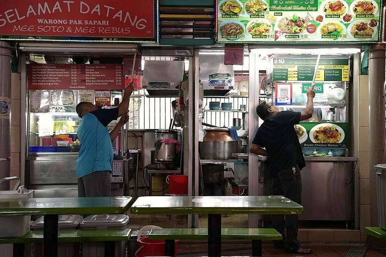 Hawkers cleaning their stalls at Adam Road Food Centre on Monday. Under the SG Clean initiative launched last month, stalls that meet cleanliness requirements get an SG Clean quality mark. ST PHOTO: KUA CHEE SIONG