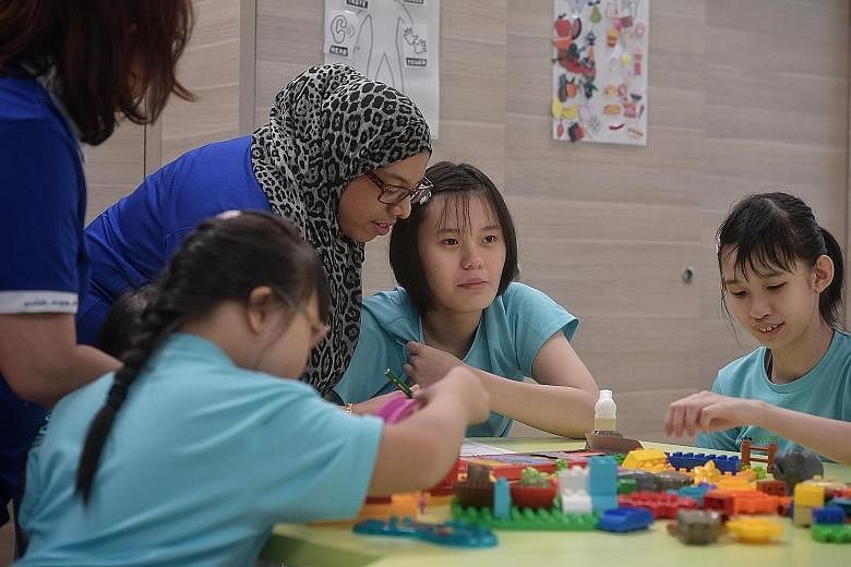 Kylie Tan (at right), 17, attends a special student care centre run by Minds. With the higher subsidy, her mother needs to pay only $35 a month, instead of $106, for her fees.
